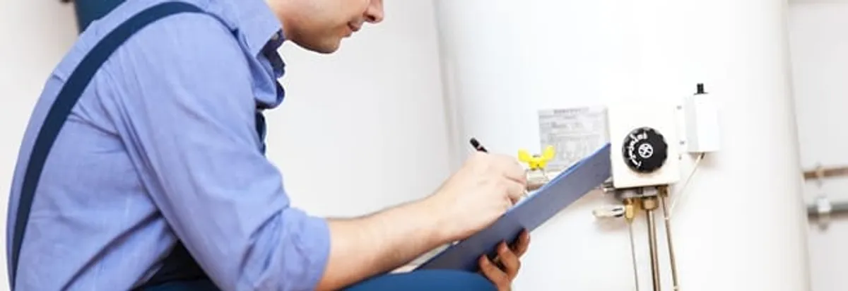 Water heater repair technician inspecting the unit and recording service notes in Newark, NJ